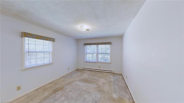 carpeted spare room featuring a baseboard heating unit, baseboards, and a textured ceiling