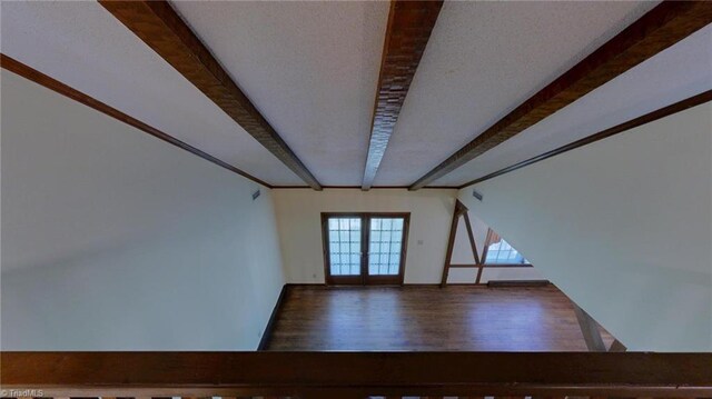 interior space featuring french doors, wood finished floors, and beamed ceiling