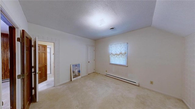 spare room featuring a textured ceiling, vaulted ceiling, baseboards, light colored carpet, and a baseboard radiator