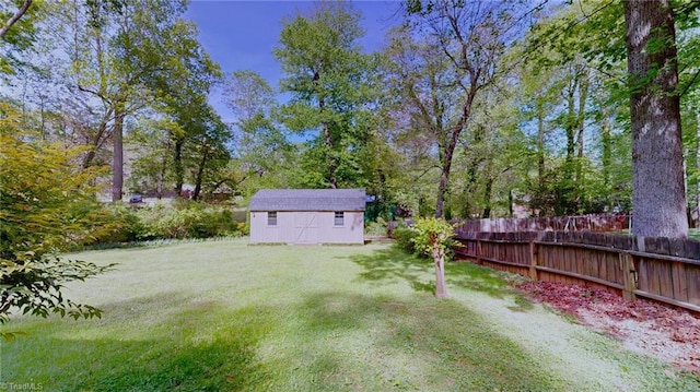view of yard featuring an outdoor structure, a shed, and fence