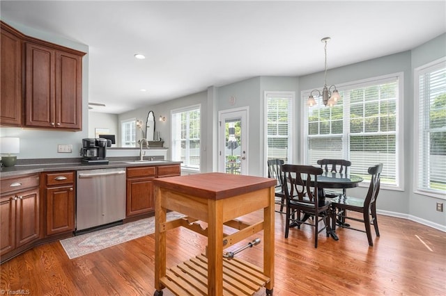 kitchen featuring stainless steel dishwasher, a sink, light wood-style flooring, plenty of natural light, and recessed lighting
