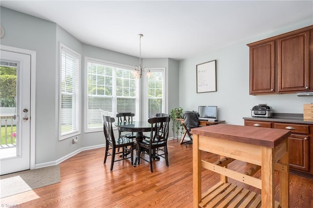 dining space featuring healthy amount of natural light, light wood-type flooring, and baseboards