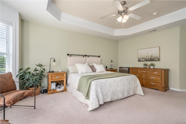 bedroom with carpet, crown molding, a tray ceiling, and ceiling fan