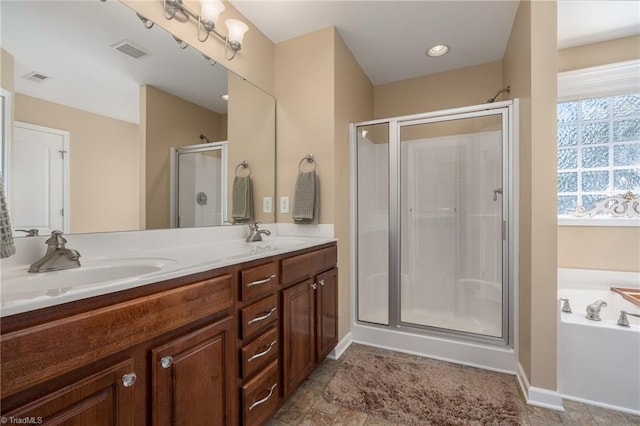 full bathroom with a shower stall, a bath, double vanity, and baseboards