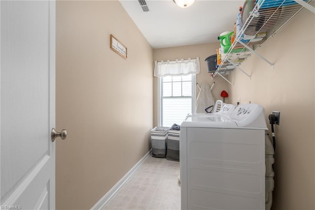clothes washing area featuring separate washer and dryer and baseboards