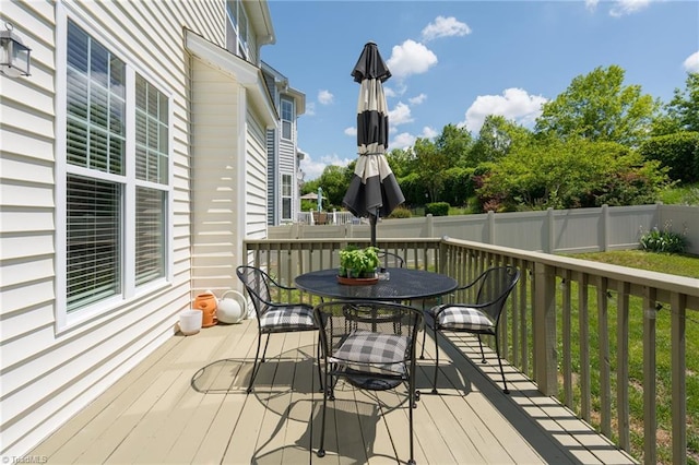 wooden terrace featuring outdoor dining area and fence