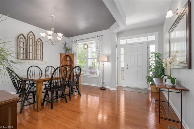 dining room featuring wood finished floors, a chandelier, and baseboards