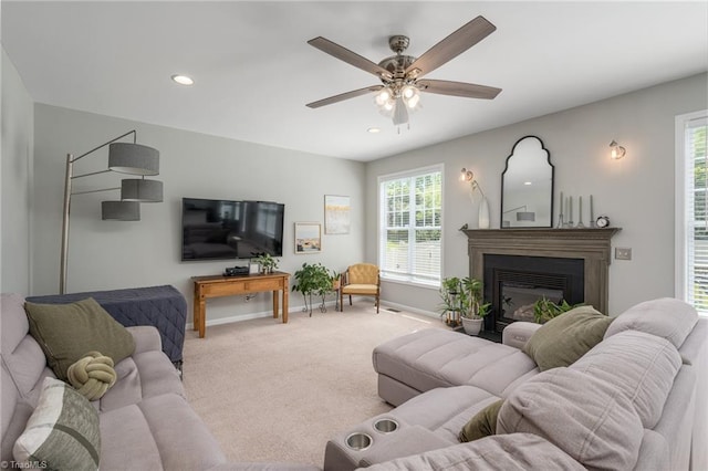 carpeted living room featuring baseboards, recessed lighting, ceiling fan, and a glass covered fireplace