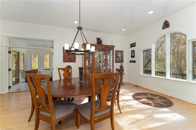 dining room featuring light wood-type flooring and an inviting chandelier