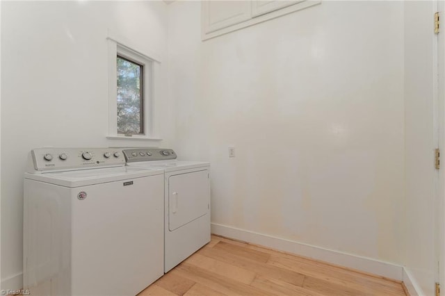 laundry area featuring separate washer and dryer and light hardwood / wood-style flooring