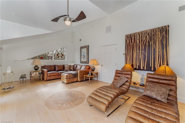 living room with hardwood / wood-style floors, high vaulted ceiling, and ceiling fan