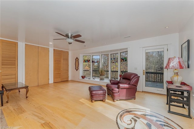 living room with ceiling fan and light hardwood / wood-style floors