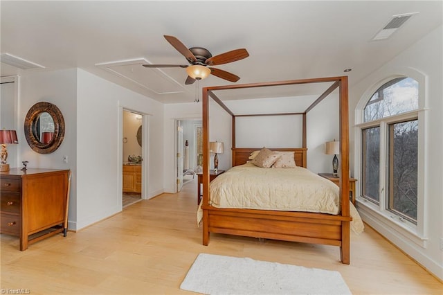 bedroom with ceiling fan, light wood-type flooring, and ensuite bath