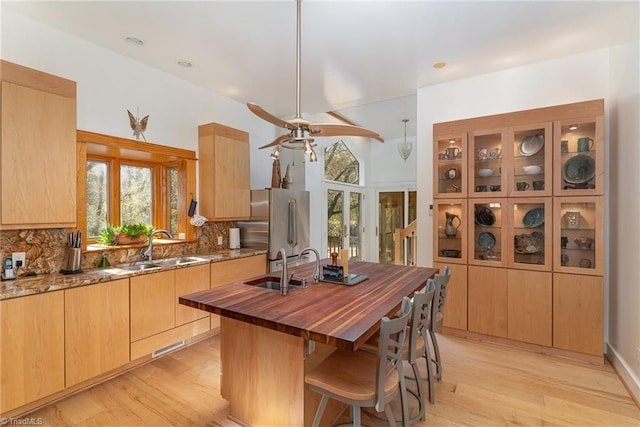 kitchen with decorative backsplash, light hardwood / wood-style flooring, and a healthy amount of sunlight