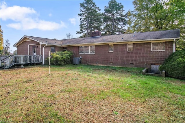 rear view of property featuring central AC unit, a yard, and a wooden deck