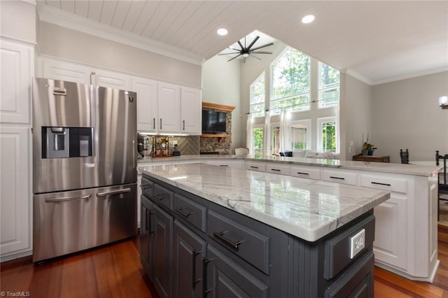kitchen with a peninsula, a center island, stainless steel fridge with ice dispenser, white cabinetry, and dark wood finished floors