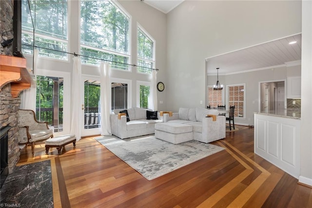 living area featuring a notable chandelier, a high ceiling, and wood finished floors