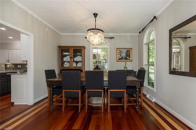 dining space with baseboards, dark wood finished floors, an inviting chandelier, and crown molding