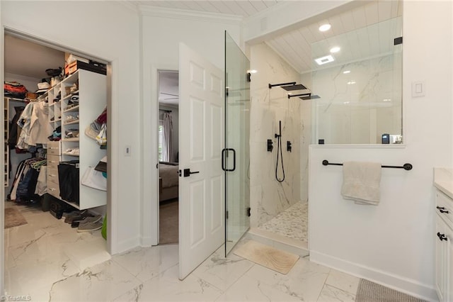 bathroom with a marble finish shower, a walk in closet, baseboards, marble finish floor, and ornamental molding