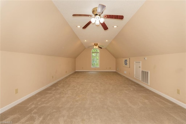bonus room with baseboards, light carpet, visible vents, and vaulted ceiling