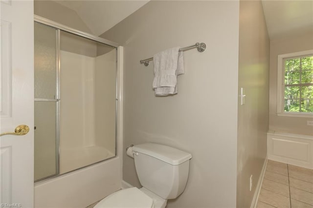 full bath featuring vaulted ceiling, tile patterned flooring, toilet, and bath / shower combo with glass door