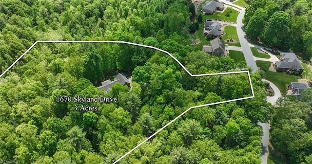 birds eye view of property featuring a view of trees