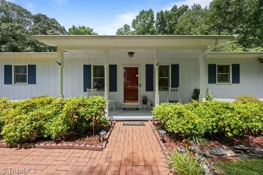 1630 Ploughboy Ln, Winston-Salem, NC 27103 - view of exterior entry with covered porch and board and batten siding