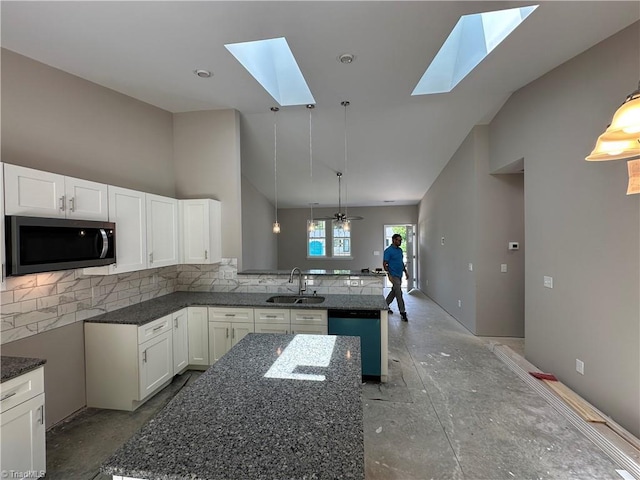 311 W Market St, Graham, NC 27253 - kitchen with stainless steel microwave, a sink, dishwasher, a skylight, and a peninsula