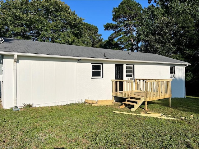 back of property featuring a wooden deck and a yard