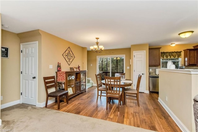 dining space featuring light hardwood / wood-style flooring and a notable chandelier