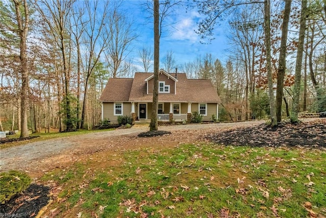 cape cod-style house with covered porch and a front lawn