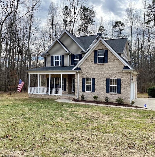 view of front of property with a garage, a front lawn, and a porch