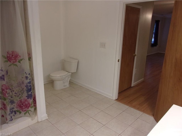 bathroom with curtained shower, hardwood / wood-style floors, and toilet