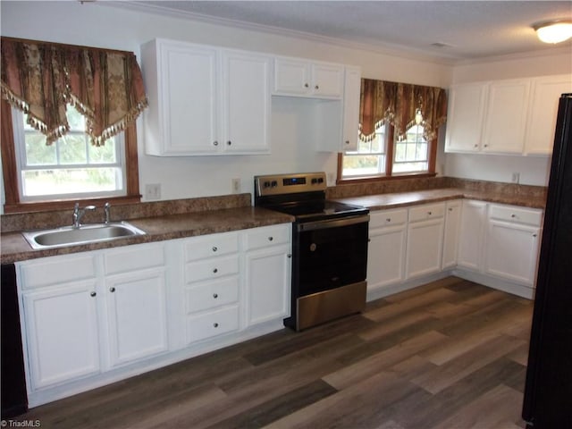 kitchen with electric stove, plenty of natural light, and white cabinetry