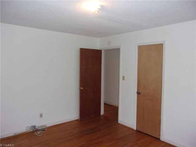 unfurnished room with a textured ceiling and hardwood / wood-style floors