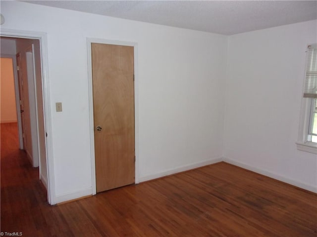 unfurnished bedroom with dark wood-type flooring