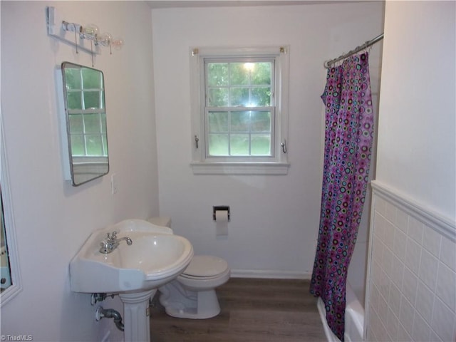 full bathroom featuring tile walls, shower / bath combo with shower curtain, toilet, hardwood / wood-style floors, and sink