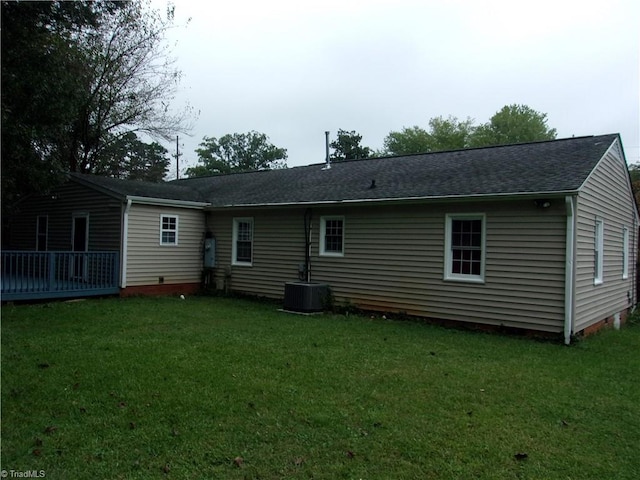 back of house with a lawn and central air condition unit