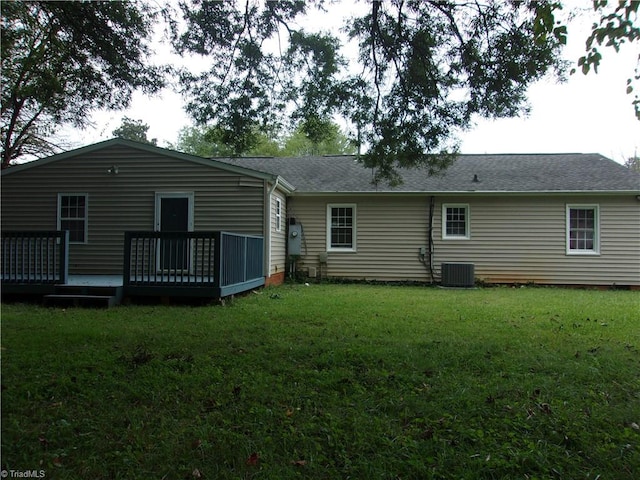 back of property featuring central AC unit, a deck, and a yard