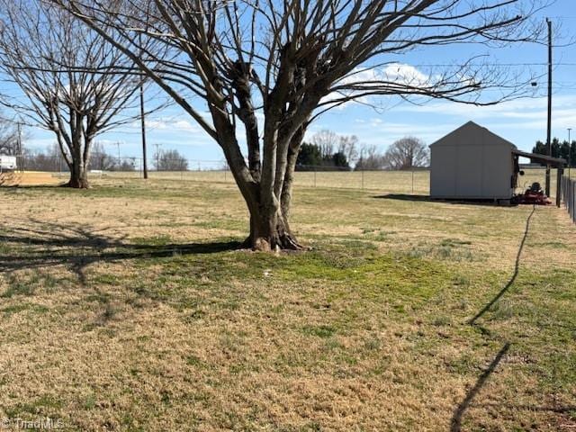 view of yard with a rural view, a storage unit, and an outdoor structure