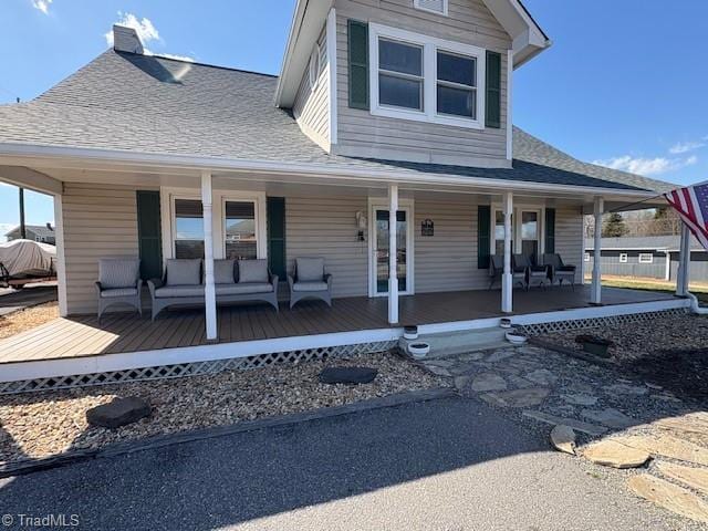 view of front of house featuring outdoor lounge area, a porch, and a shingled roof