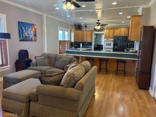 living room with light wood finished floors, recessed lighting, a ceiling fan, and crown molding