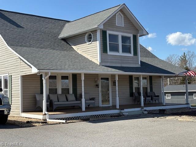 view of front facade with a porch and a shingled roof