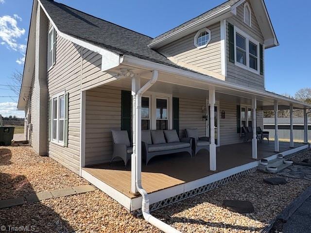 view of front facade with an outdoor hangout area, a porch, and roof with shingles