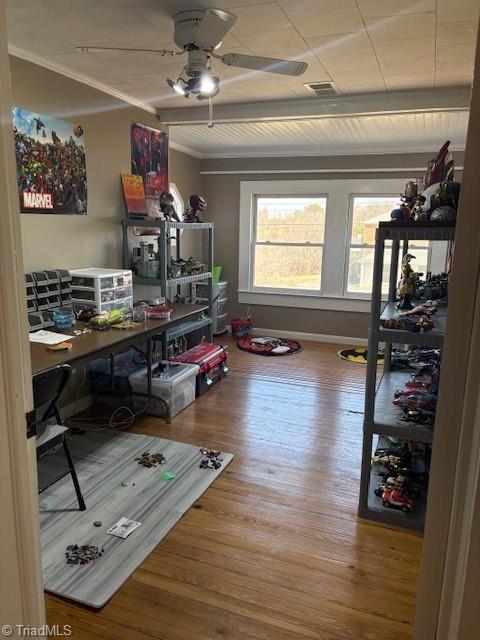 office space with ceiling fan, wood finished floors, visible vents, baseboards, and crown molding