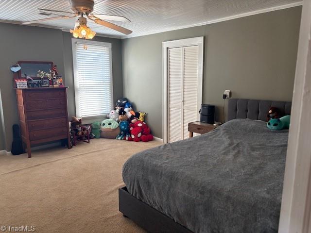 carpeted bedroom featuring a ceiling fan and a closet