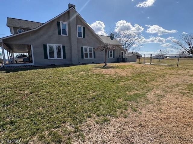 rear view of property featuring a yard and a chimney