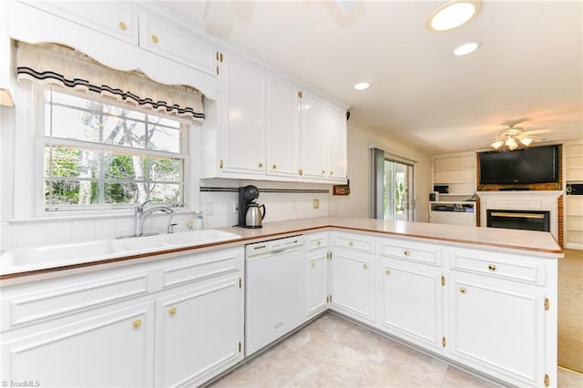 kitchen featuring light countertops, white cabinets, a peninsula, dishwasher, and ceiling fan