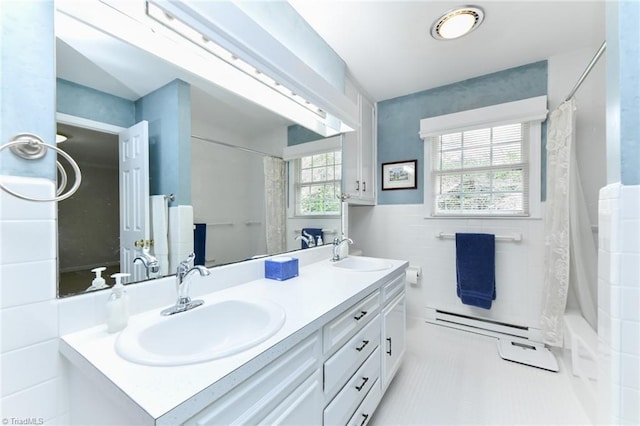 bathroom with a shower with curtain, tile walls, double vanity, and a sink