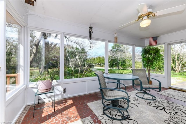 sunroom with plenty of natural light, brick floor, and a ceiling fan